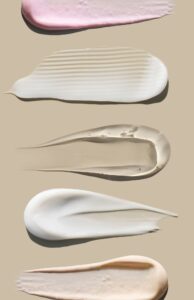 creamy texture of cosmetic samples on a pastel beige background